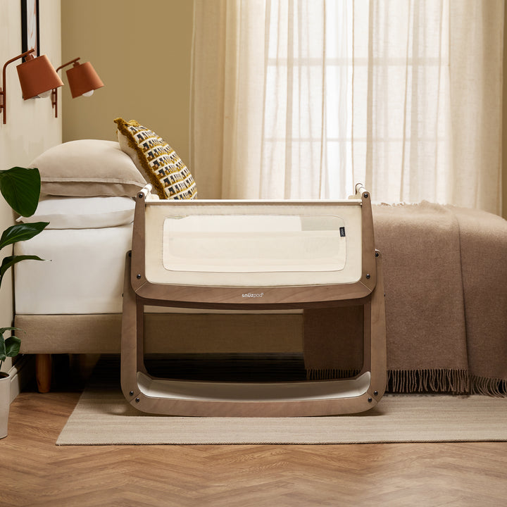 A baby in a beige and brown SnúzPod 5